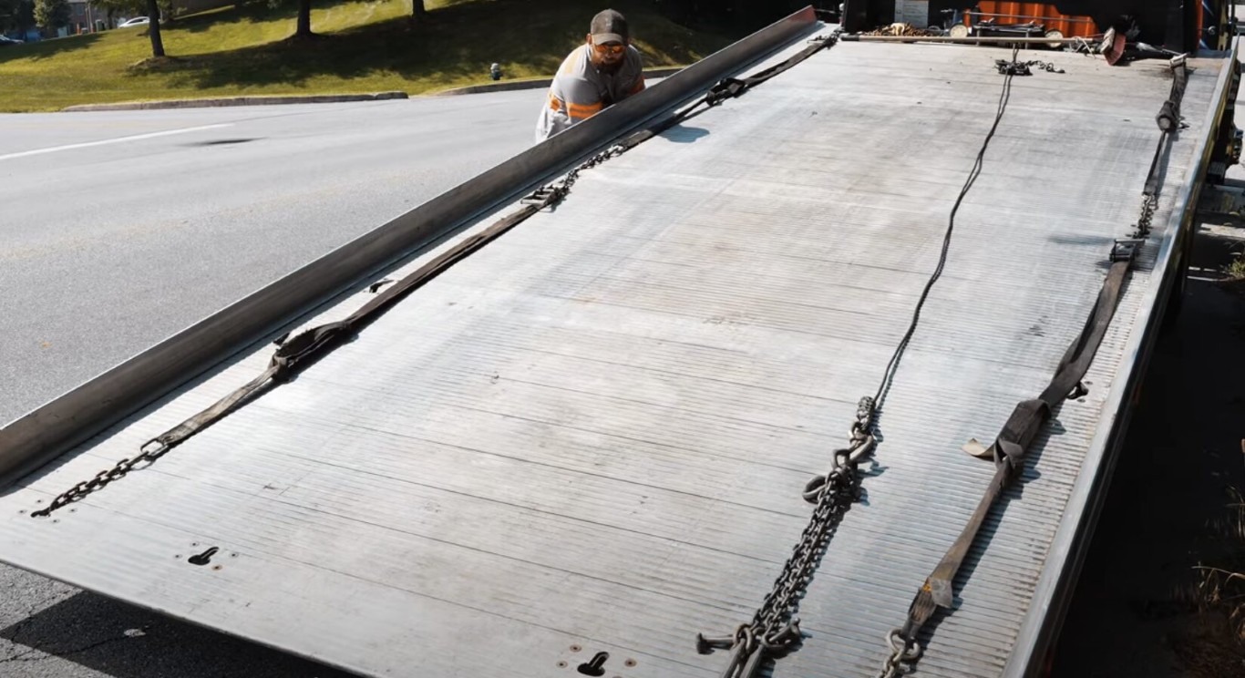 Flatbed tow truck with securing chains ready for vehicle transport in Carmel, IN